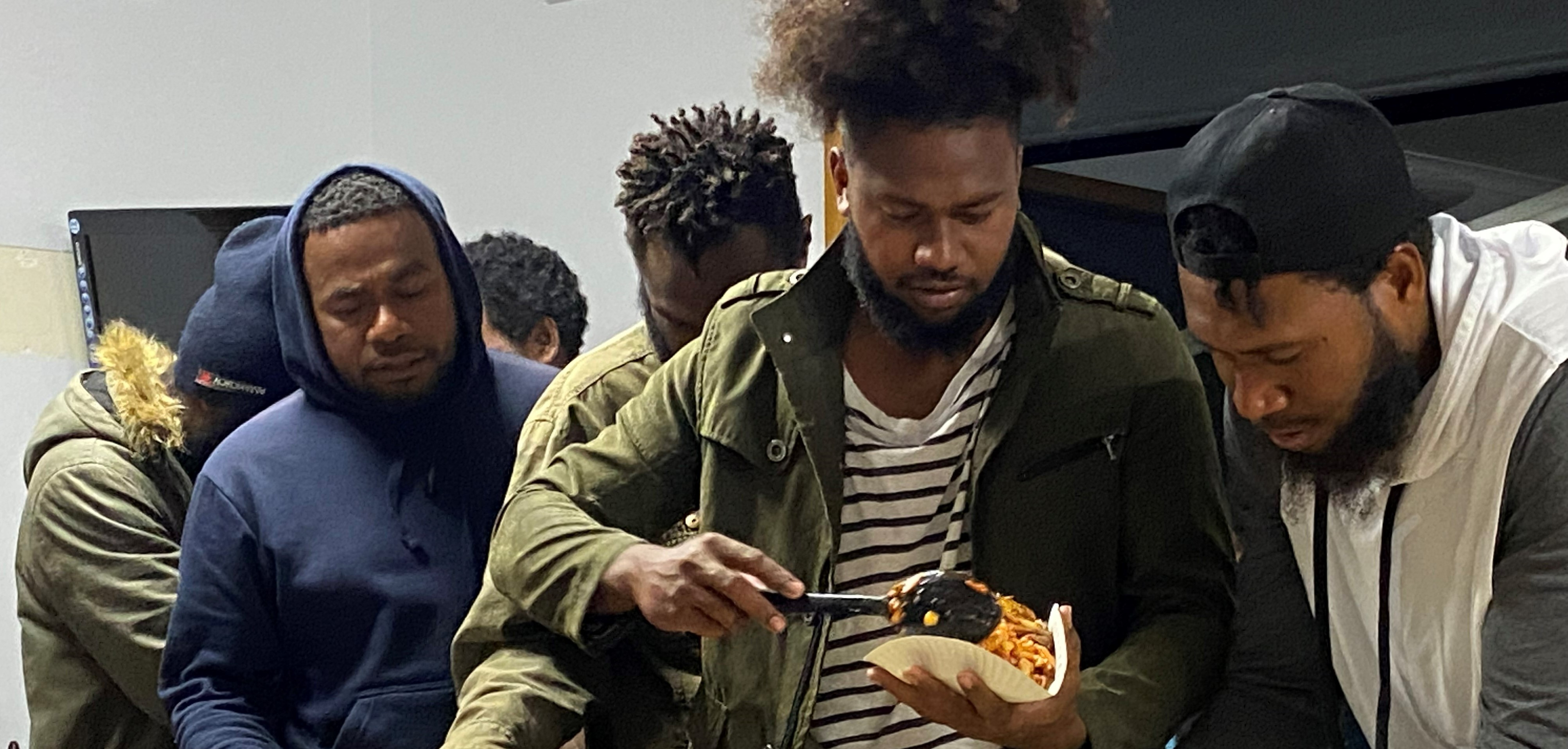 Pacific Islands men serve food.