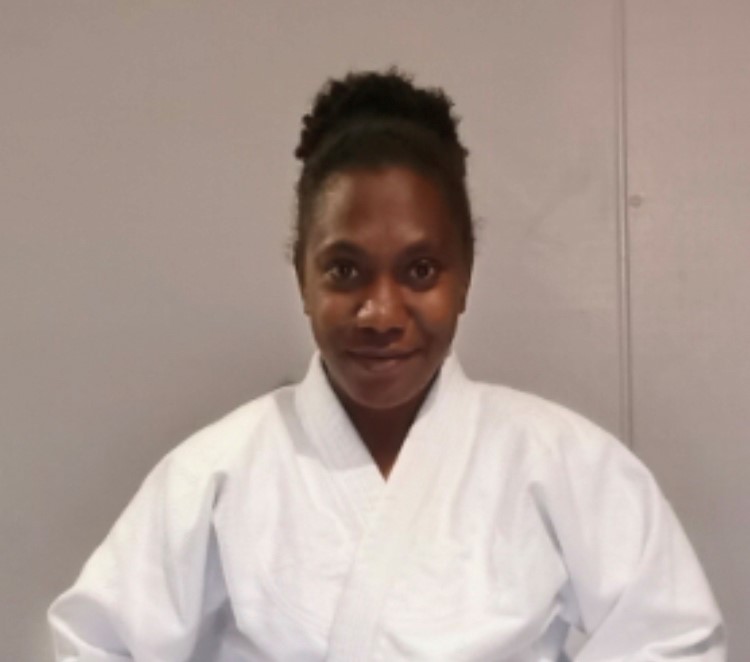 A ni-Vanuatu woman in a white judo outfit.