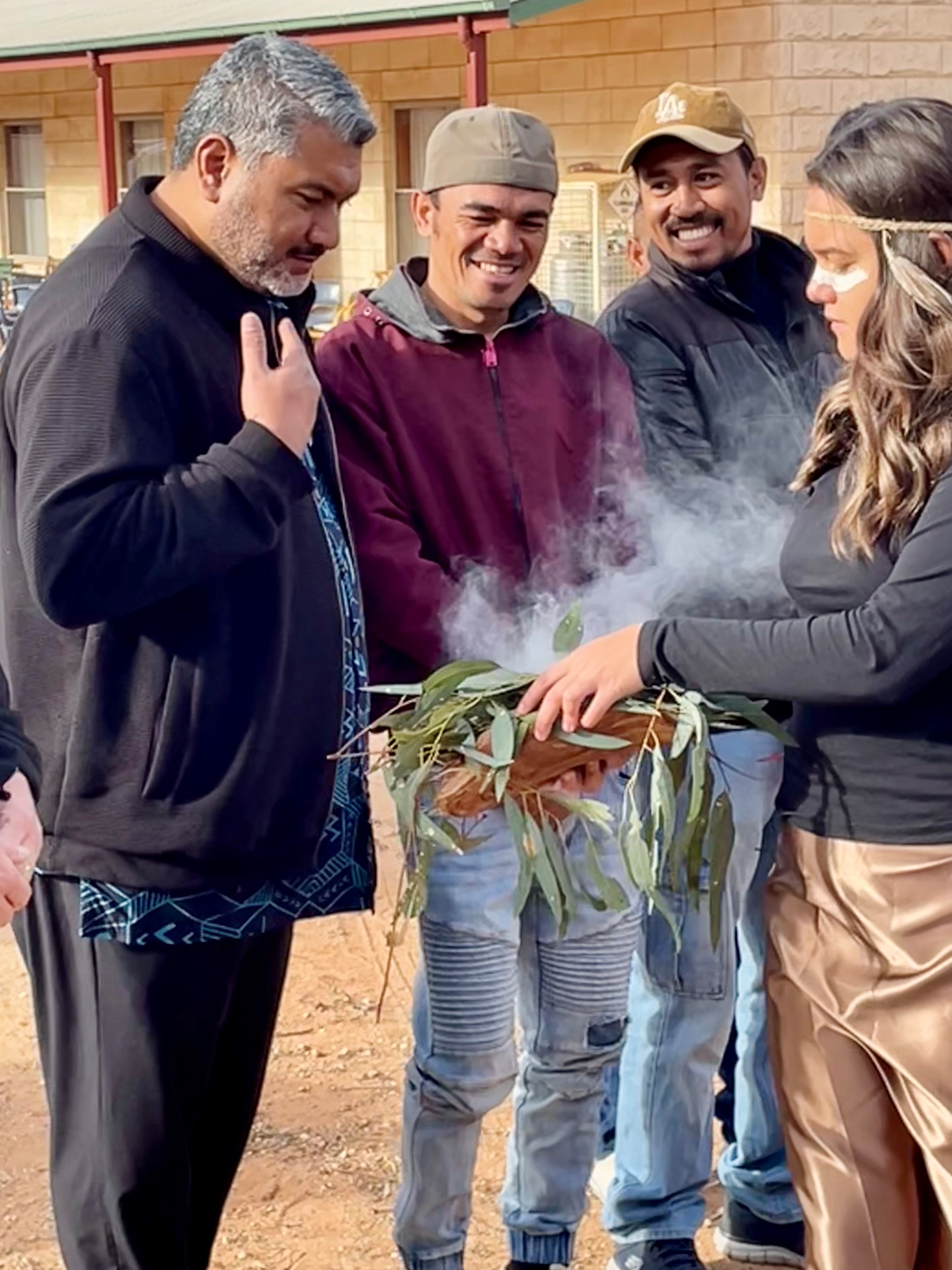PALM scheme partner and workers taking part in the smoking ceremony.