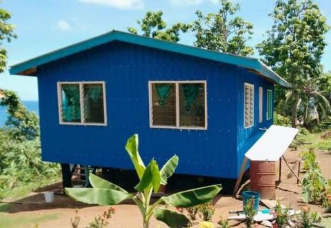 A blue house on a property overlooking the ocean in Solomon Islands.