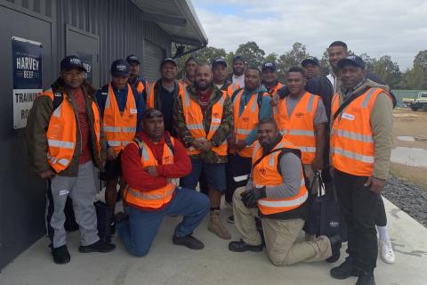 Pacific islanders in orange high visibility clothing.