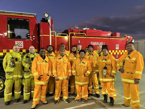 Fijian and Australian volunteer firefighters standing by firetruck