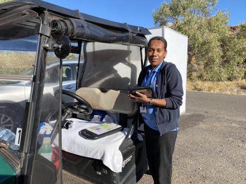 A woman in a uniform standing beside a buggy