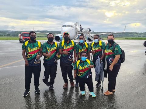 Elie with teammates on the tarmac at an airport