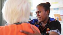A Solomon islands aged care worker helps a resident