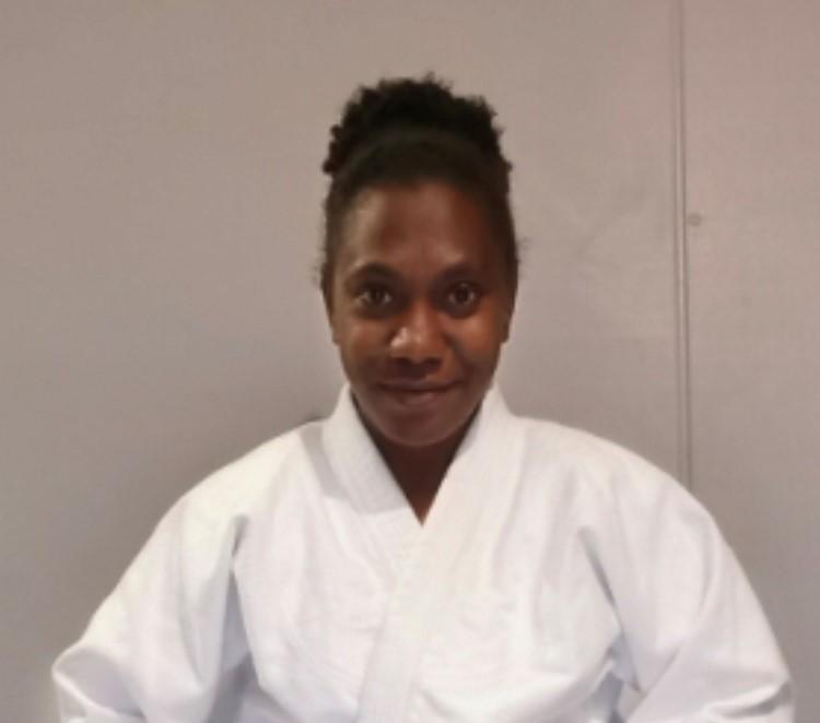 A ni-Vanuatu woman in a white judo outfit.