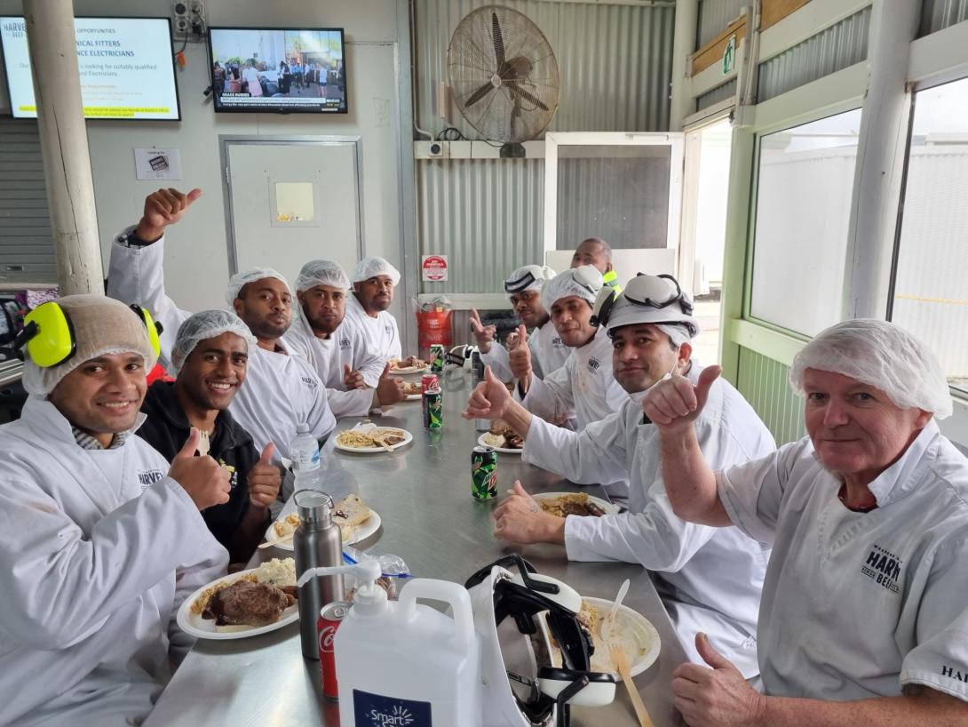 Pacific Island men in white clothing in a breakroom.