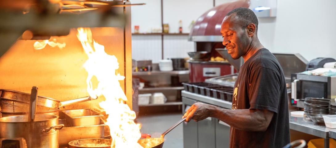 A man cooking in a commercial kitchen