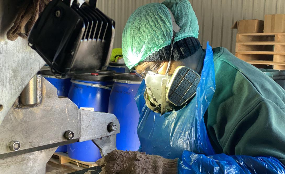 Elie working at a machine in her workplace 